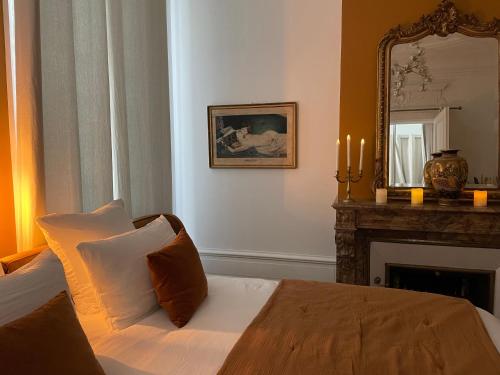 a bedroom with a bed with a mirror and a fireplace at Maison Marie-Astrid, Suite avec Balnéo privée in Bordeaux