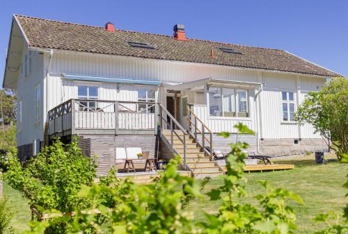 a large white house with a porch and stairs at Rosenhill Bed & Breakfast in Grebbestad