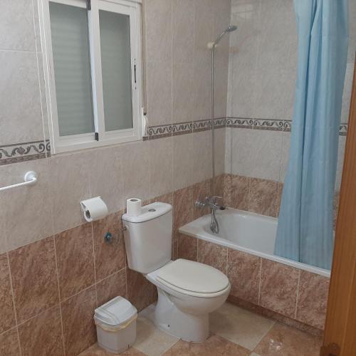 a bathroom with a toilet and a bath tub at Hostal Los Amigos in La Roda
