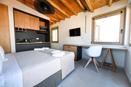 a bedroom with a bed and a desk and a window at Eumorphia Studios & Apartments in Skiathos Town