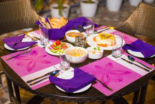 a table with purple napkins and plates of food on it at Regenta Inn Amristar Airport Road by Royal Orchid Hotels Limited in Amritsar