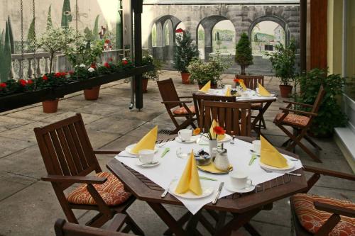 un patio con mesas y sillas y servilletas amarillas. en Central Hotel Garni, en Würzburg