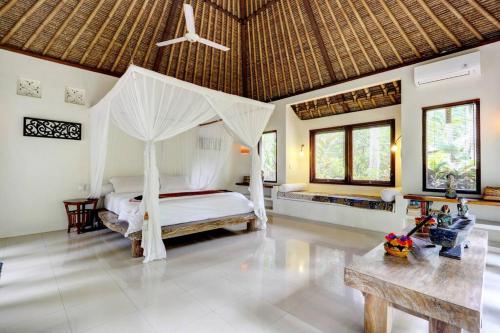 a bedroom with a bed with a canopy at Rumah Kelapa Sepi in Karangasem