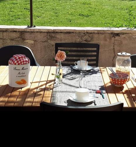 a wooden table with a table cloth on top of it at Au Chat Perché chambre double in Mareil-sur-Mauldre