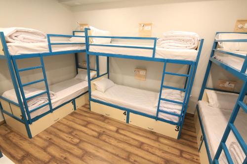 a room with three bunk beds in a room at Blue Beds Hostel in Jaipur