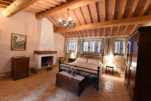 ein Schlafzimmer mit einem Bett und einem Kamin in der Unterkunft Piccolo Borgo Gagnoni in Sinalunga