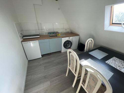 - une petite cuisine avec une table et des chaises dans la chambre dans l'établissement Zentral gelegenes Apartment am Bunter Garten, à Mönchengladbach