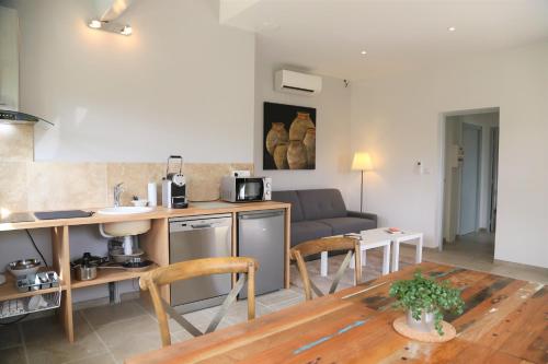 a kitchen and living room with a table and a couch at Domaine de La Font des Pères - Teritoria in Le Beausset