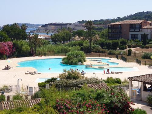 une grande piscine avec des gens dans un complexe hôtelier dans l'établissement Superbe appartement 2 chambres piscine et plage, à Gassin