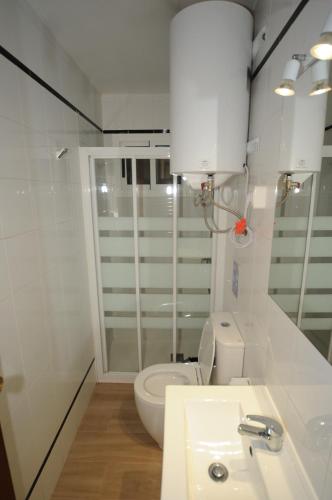 een witte badkamer met een toilet en een wastafel bij Orange Park Apartamento Jardin in Benicàssim