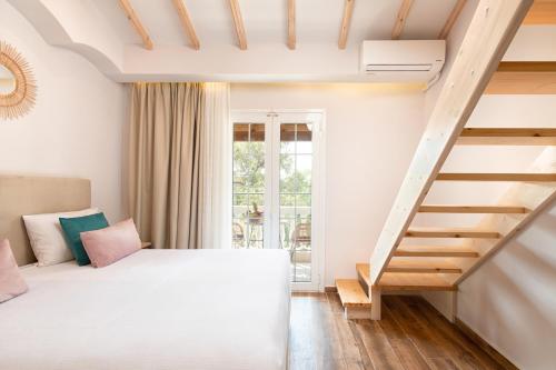 a bedroom with a bed and a staircase at KORINA APART HOTEL KAVOS in Kavos