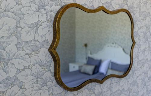 a mirror on a wall with a bed in a bedroom at Rosenhill Bed & Breakfast in Grebbestad