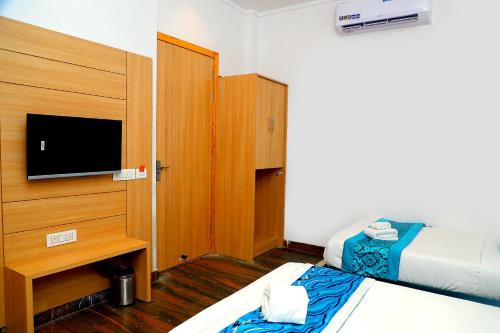 a hotel room with two beds and a flat screen tv at Hotel Diamond View in Amritsar