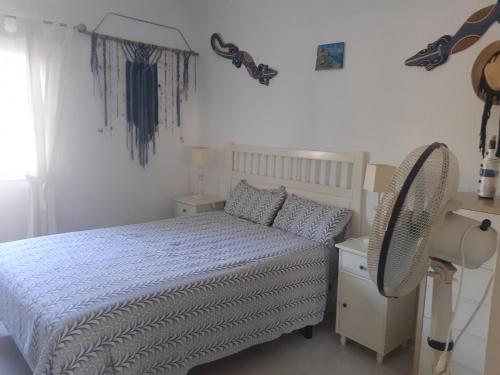 ein weißes Schlafzimmer mit einem Bett und einem Schreibtisch in der Unterkunft Mi morena cala llobeta 35 in L'Ametlla de Mar