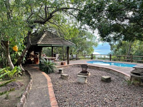 un jardín con cenador y piscina en Cycad Rock Fishing Lodge, en Jozini