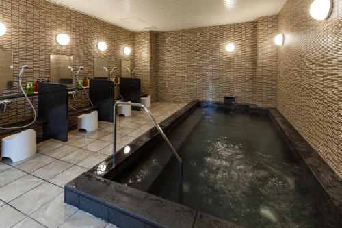 a bathroom with a large pool of water at Y's HOTEL Hanshin Amagasaki Ekimae in Amagasaki