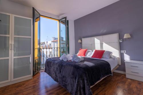 a bedroom with a large bed with a large window at Reservaloen Terrazas de la Catedral in Seville