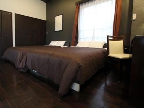 Un dormitorio con una cama grande y una ventana en HOTEL LiVEMAX BUDGET Esaka, en Suita