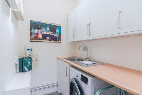 a kitchen with a sink and a washing machine at The Barn at Kington Grange in Claverdon