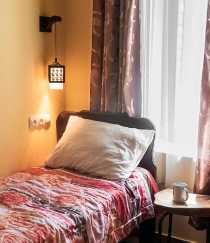 a bed with a white pillow and a window at Telavi Tel Aviv in Tʼelavi
