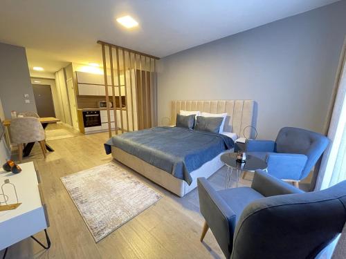 a bedroom with a bed and a living room at Downtown Apartments in Pristina