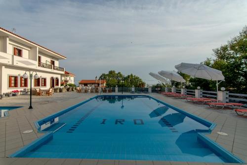 a large blue swimming pool next to a building at Iro's Residence in Ágios Konstantínos
