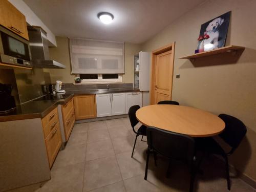 a kitchen with a wooden table and black chairs at Susberg 3 in Pelt
