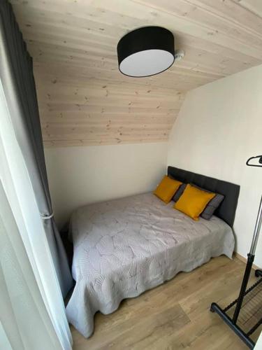 a bedroom with a bed with yellow pillows at Sun&Sea in Palanga