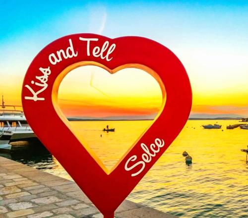a heart sign on the beach with the sunset at MiraMa MobileHome in Selce