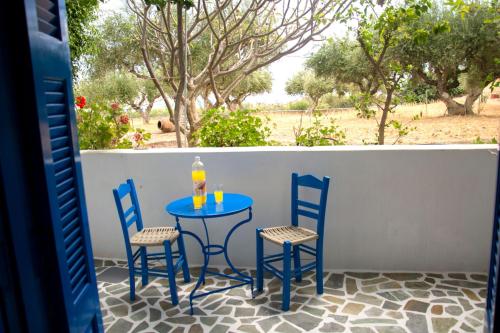 a blue table and two chairs on a patio at Vardes Hotel Studios in Amoopi