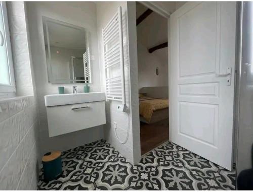 Un baño blanco con lavabo y espejo. en The California Dream - hyper-centre - 2mn gare SNCF - WIFI NETFLIX gratuit, en Niort