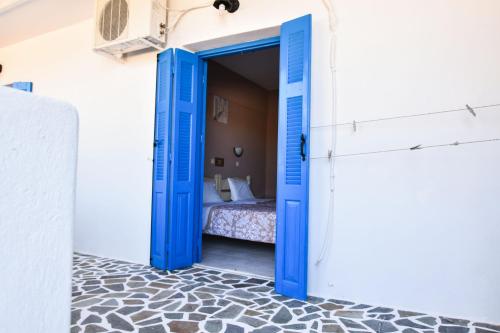 a blue door leading into a bedroom with a bed at Vardes Hotel Studios in Amoopi
