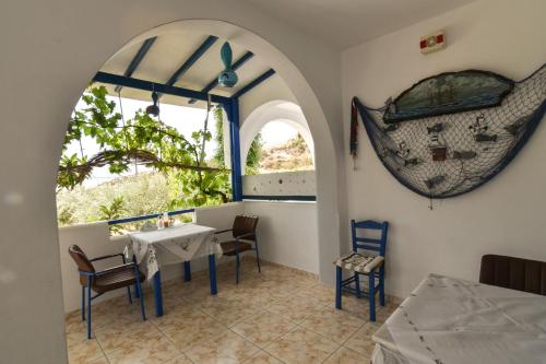 a dining room with a table and chairs and a window at Vardes Hotel Studios in Amoopi