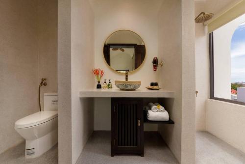 La salle de bains est pourvue de toilettes et d'un miroir. dans l'établissement Hoianoi Villa_A Little Hoi An_Entire villa, à Hội An