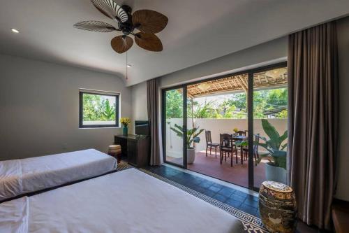 a bedroom with a bed and a balcony with a dining room at Hoianoi Villa_A Little Hoi An_Entire villa in Hoi An