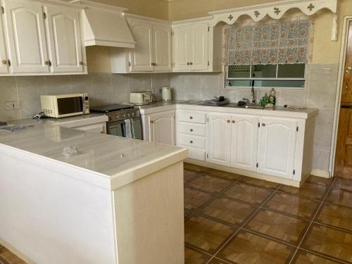 una cucina con mobili bianchi e un piano di lavoro di Stunning 2-Bed Apartment in Grand Roy Grenada a Mount Nesbit