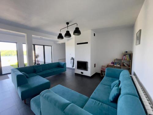 a living room with two blue couches and a tv at Jaworowy Dom in Solina