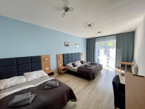 a bedroom with two beds and a large window at Jaworowy Dom in Solina