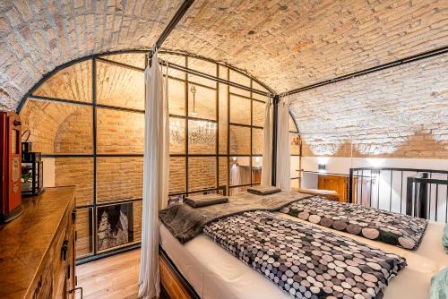 ブダペストにあるLiszt Designer 2Bedroom Center Apartmentのレンガの壁に大きなベッドが備わるベッドルーム1室が備わります。