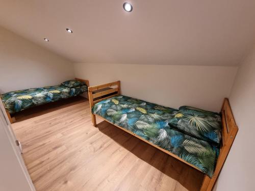 two beds in a room with wooden floors at Susberg 4 in Pelt