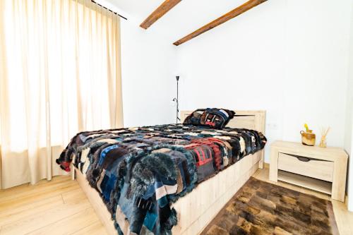 a bedroom with a bed with a blanket on it at Apartamentai Muzika in Šilutė