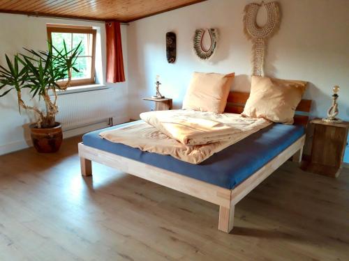 a bedroom with a bed with a blue mattress at Ein Bett im Kornfeld - Haus Fernweh - Innenpool in Schönfeld