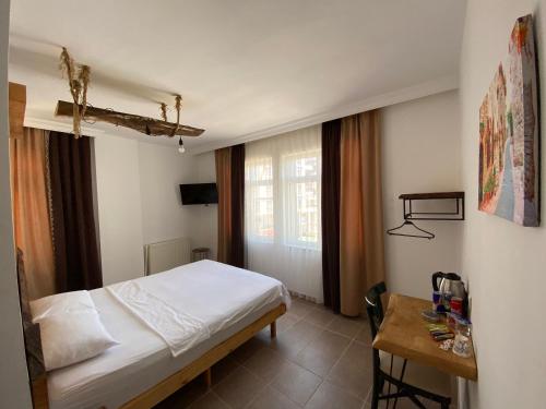 a bedroom with a bed and a table and a window at Medi Otel in Samsun