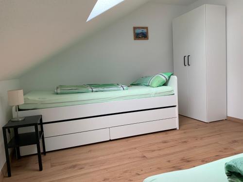a bed in a white room with a bedvisor at Ruhige Ferienwohnung nähe des Zentrums in Marktoberdorf