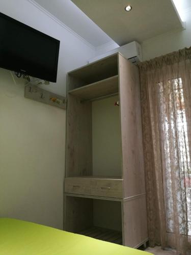 a bedroom with a tv and a dresser with a mirror at small booking room in Sarti
