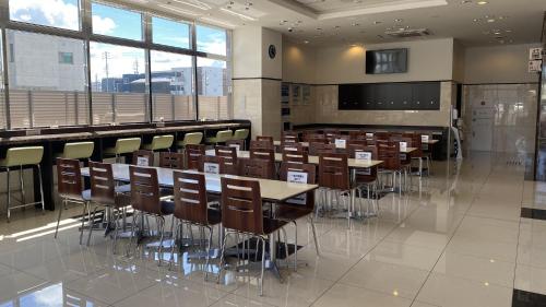 a conference room with tables and chairs and windows at Toyoko Inn Meitetsu Chiryu Ekimae in Chiryu