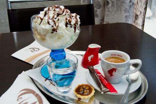 a table with a bowl of ice cream and a cup of coffee at Hello Hotels Bucuresti Gara de Nord in Bucharest