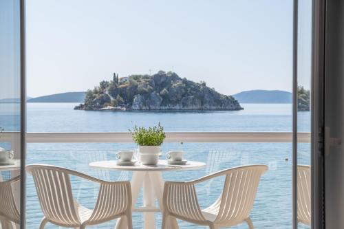 a table and chairs with a view of the ocean at Nelly's Apartments in Tolo