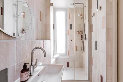 a bathroom with a sink and a shower with a mirror at Hôtel AMI - Orso Hotels in Paris