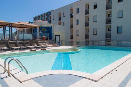 a swimming pool in front of a building at Hotel Duca Degli Abruzzi in Montesilvano